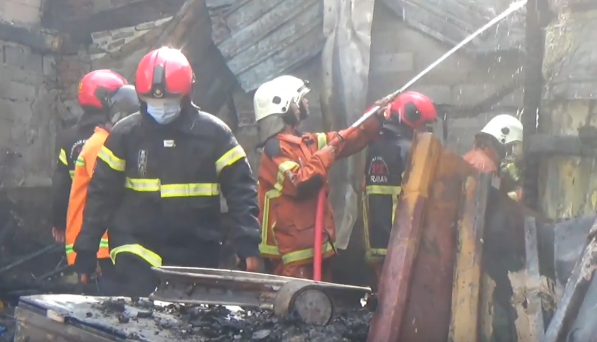 Proses pemadaman api di gudang bahan baku benang Driyorejo, Gresik (Foto / Istimewa)