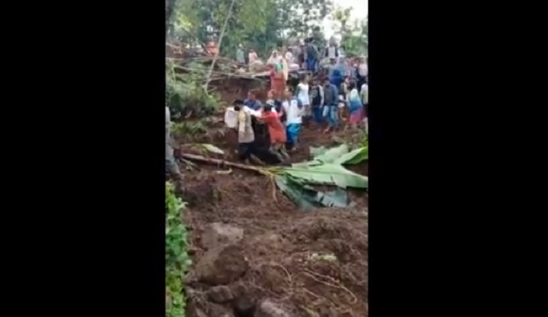 Petugas dibantu warga saat mengevakuasi  korban tertimbun longsor (Foto / Istimewa)