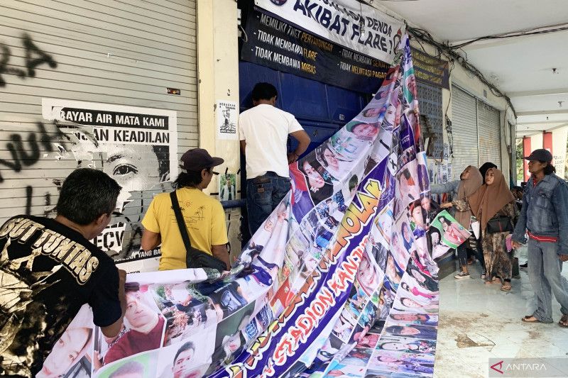 Perwakilan keluarga korban Tragedi Kanjuruhan memasang poster untuk menyampaikan penolakan mereka terhadap pembongkaran Stadion Kanjuruhan di Kabupaten Malang, Provinsi Jawa Timur, Sabtu (3/6/2023). (ANTARA/Vicki Febrianto)