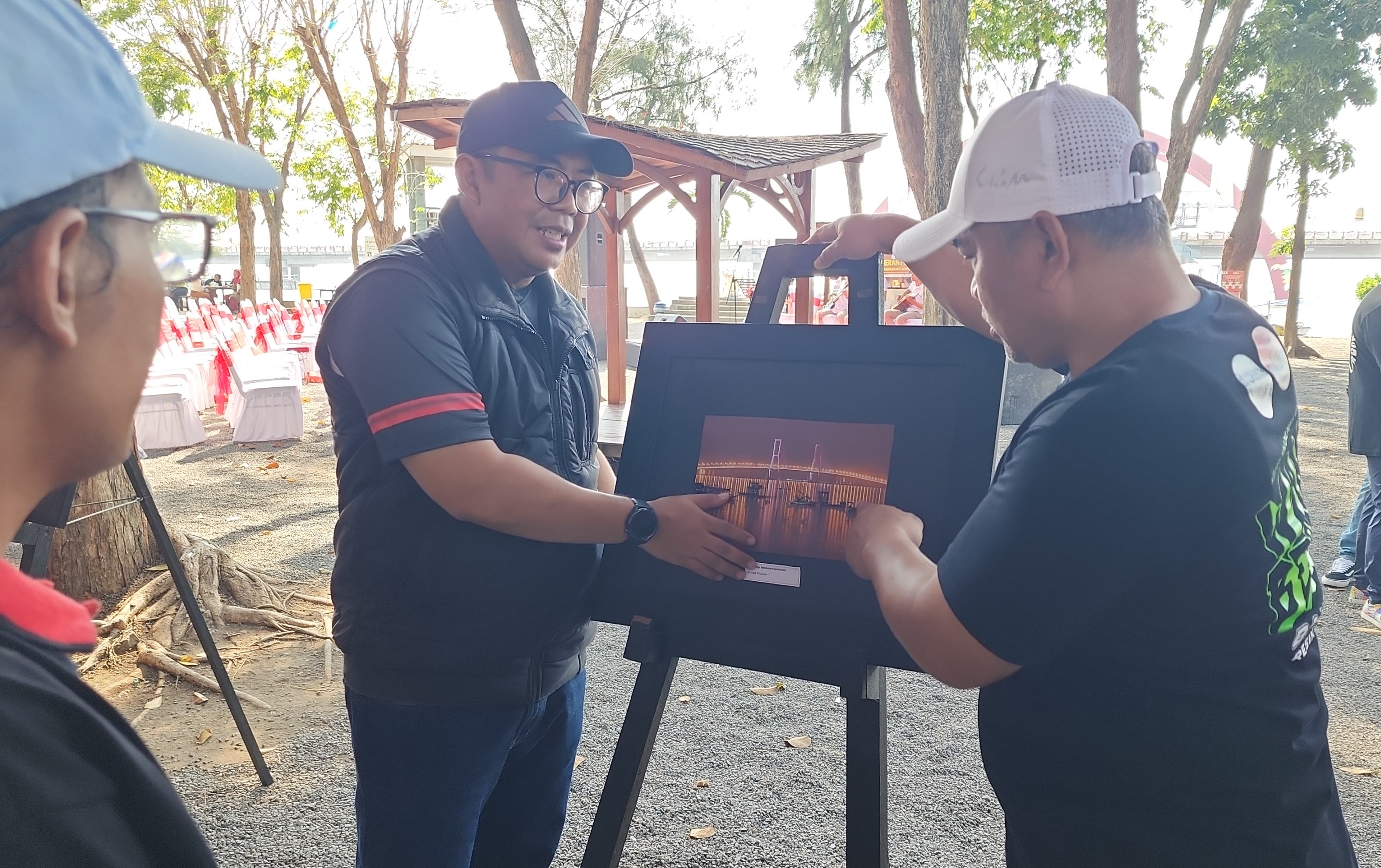Kajari Tanjung Perak, Aji Kalbu Pribadi (kiri) mengamati salah satu foto dalam pameran bersama Ketua Kompak Budi Mulyono/ist