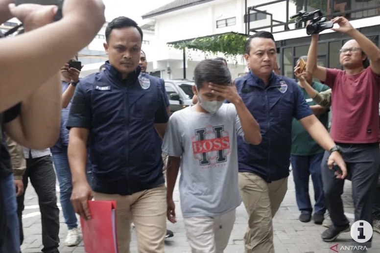 Petugas membawa tersangka AWK yang merupakan pengancam capres nomor urut 1 Anies Baswedan untuk diperiksa di Mapolda Jatim, Surabaya, Rabu (17/1/2024). ANTARA/HO-Bidhumas Polda Jatim