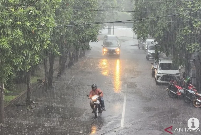 Pengendara sepeda motor saat melintas di tengah kondisi hujan di Surabaya. (ANTARA/Fiqih Arfani)