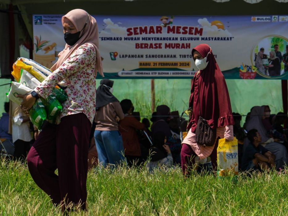 Warga membawa beras yang dibeli saat pasar murah di Lapangan Sanggrahan, Tirtoadi, Mlati, Sleman, DI Yogyakarta, Rabu (21/2/2024).(Antara/Andreas Fitri Atmoko).
