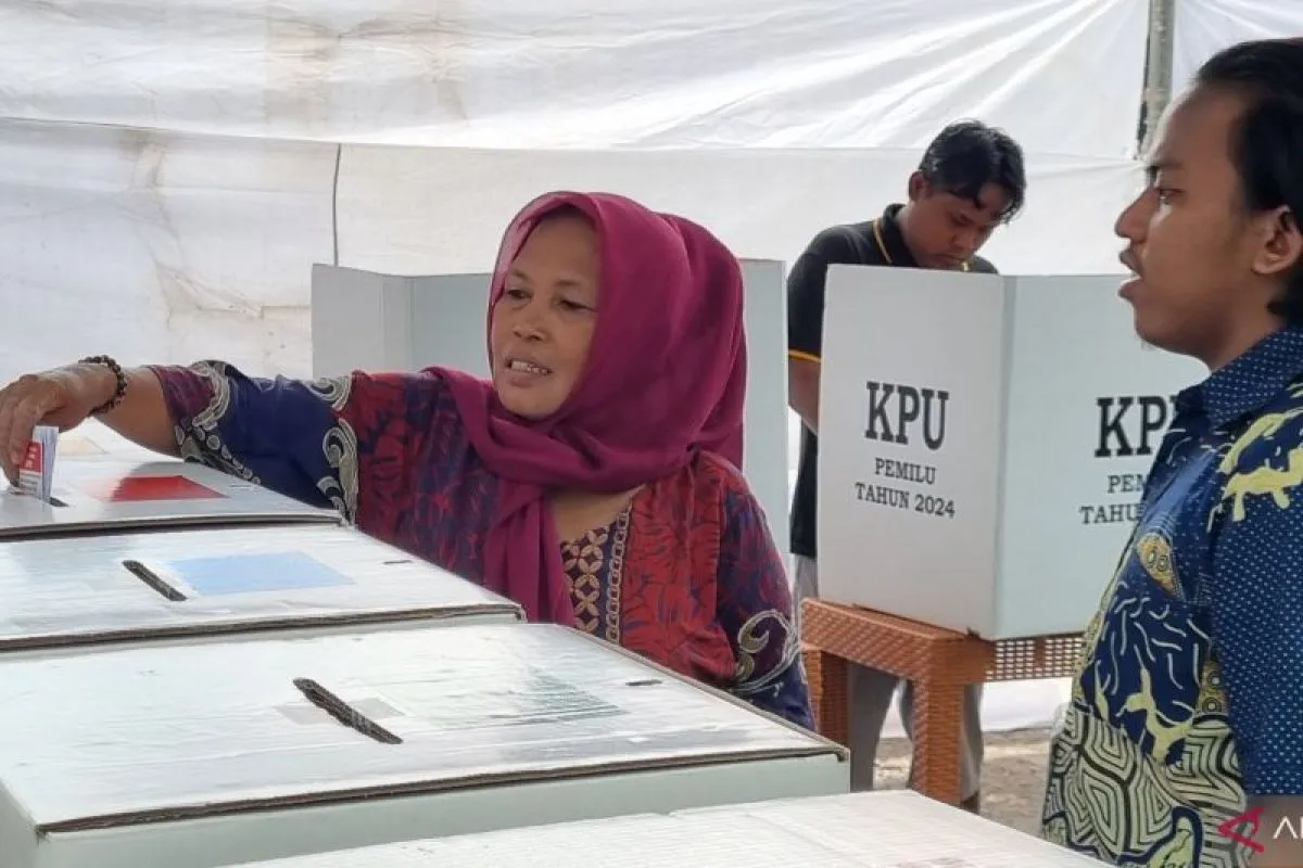 Salah seorang pemilih didampingi seorang petugas KPPS di TPS 27 Kelurahan Simolawang, Kecamatan Simokerto saat memasukkan surat suara ke dalam kotak suara, Sabtu (24/2/2024). ANTARA/Ananto Pradana.
