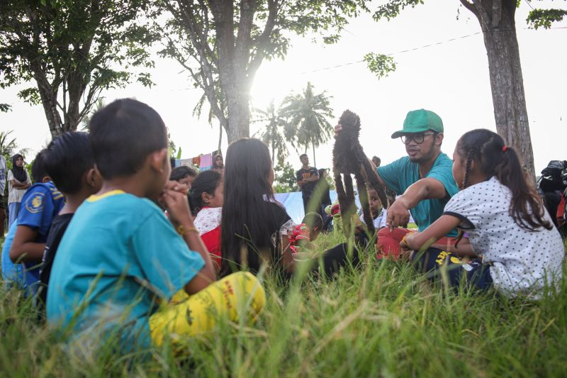 Pegiat literasi Bahana Patria Gupta bercerita kepada anak-anak terdampak gempa Bawean di Dusun Lautsungai, Sangkapura, Pulau Bawean, Gresik, Jawa Timur, Selasa (26/3/2024). Foto dari Medcom.id.