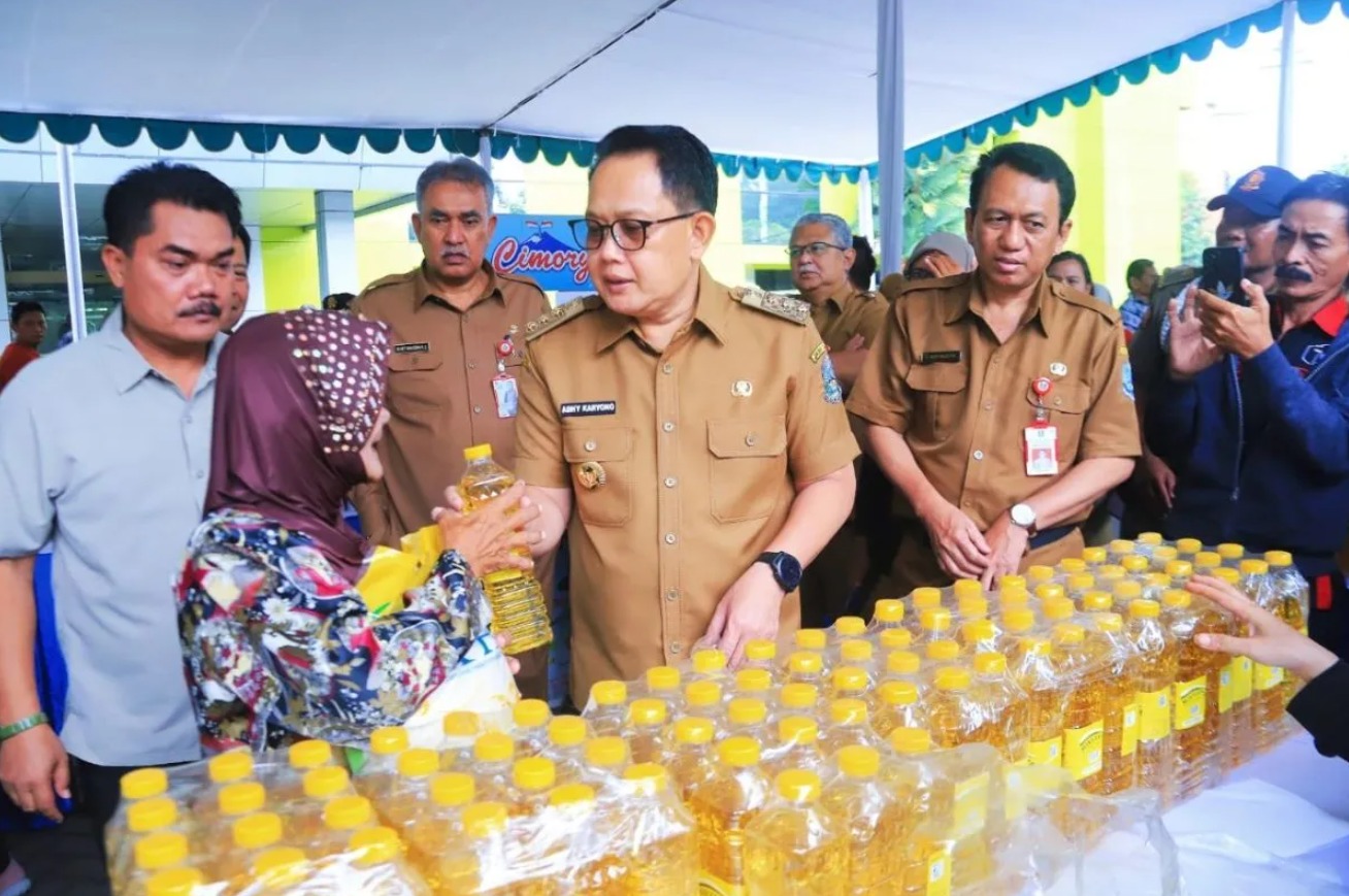 Pj Gubernur Jatim Adhy Karyono membagikan minyak goreng kepada warga dalam acara Gerakan Pangan Murah di halaman Kantor Dinas Pertanian Provinsi Jatim, Surabaya pada Senin (1/4/2024). (ANTARA/HO-Biro Adpim Jatim)
