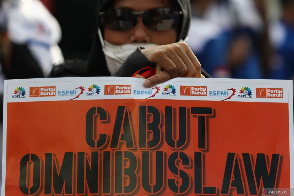 Seorang buruh memperlihatkan poster bertuliskan tuntutan saat merayakan Hari Buruh Internasional atau May Day 2024 di depan Kantor Gubernur Jatim, Surabaya pada Rabu (1/5/2024). (ANTARA/Didik Suhartono)