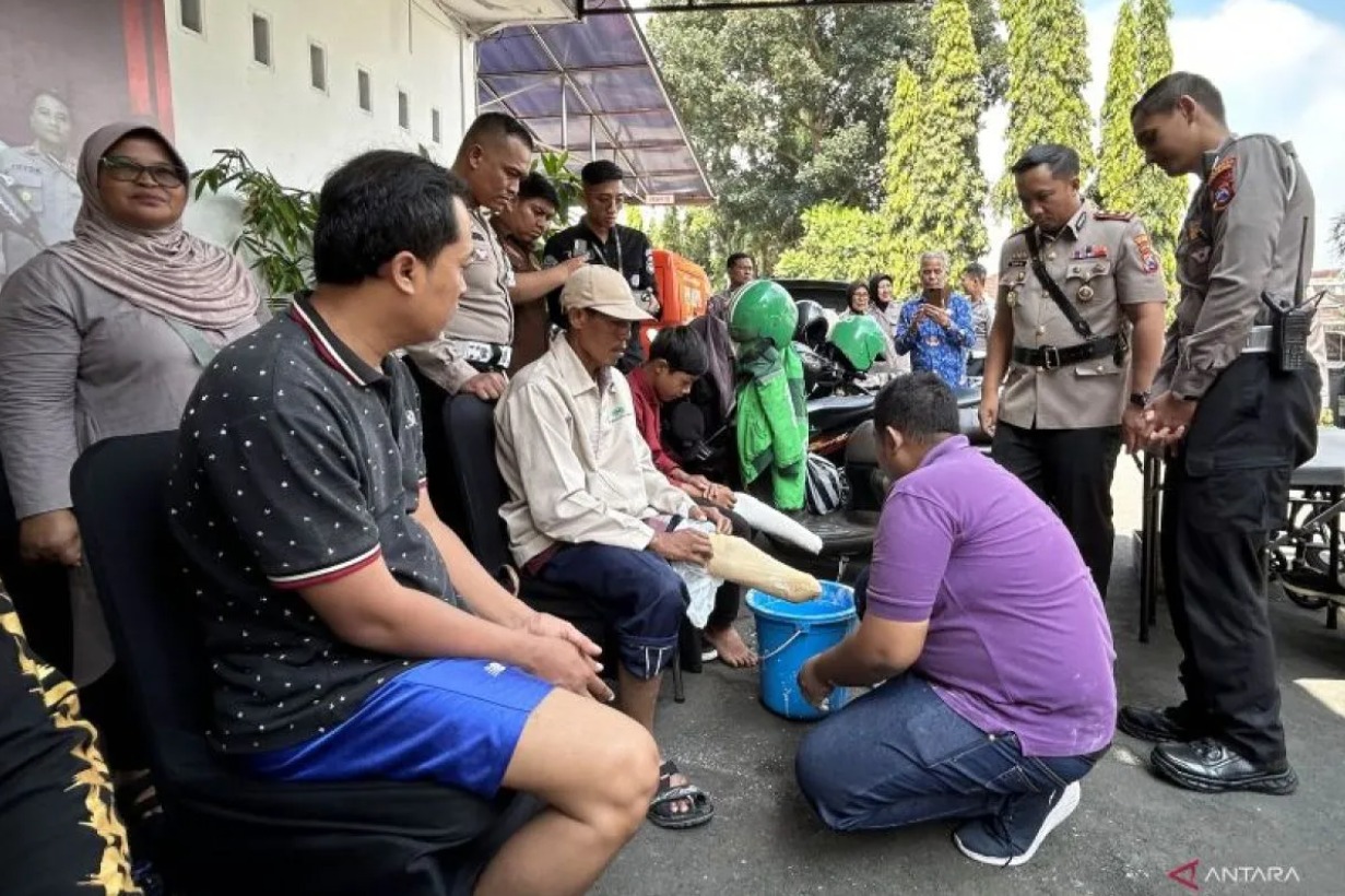 Wakapolresta Malang Kota, AKBP Apip Ginanjar (kedua kanan) dan Kasat Lantas Polresta Malang Kota, Kompol Aristianto Budi Sutrisno (kanan), ikut menyaksikan proses pembuatan kaki palsu untuk penyandang disabilitas di Mapolresta Malang, Jawa Timur pada Kami