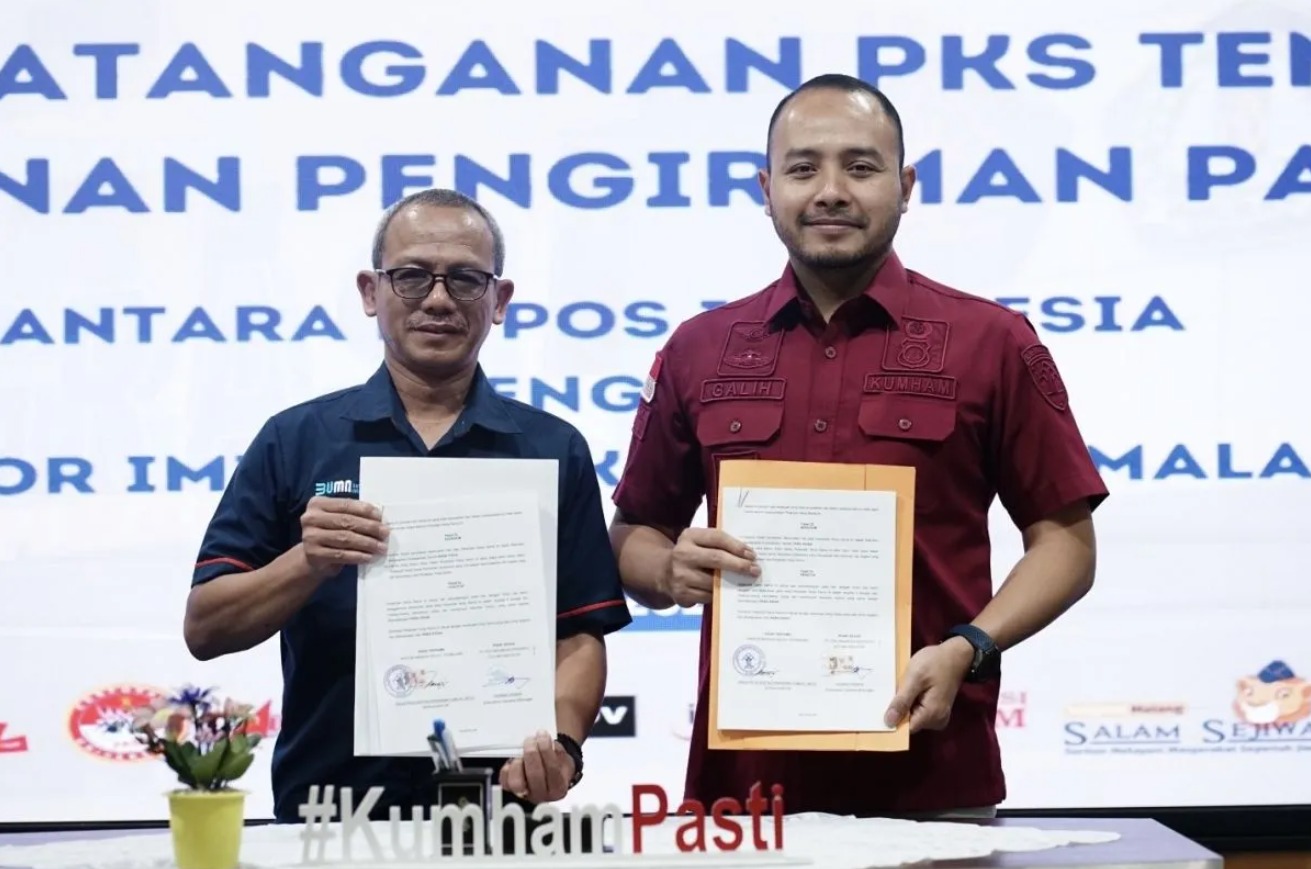 Kepala Kantor Imigrasi Malang Galih Priya Kartika Perdhana (kanan) dan Kepala PT Pos Indonesia Cabang Malang, Ahmad Ridwan menunjukkan Perjanjian Kerja Sama (PKS) di Kota Malang, Jawa Timur. Foto: ANTARA-HO-Humas Kemenkumham Jatim 