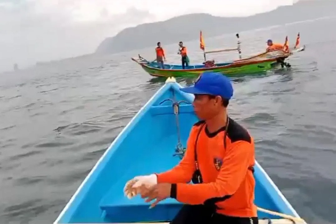 Tim SAR gabungan melakukan pencarian dengan menggunakan perahu dan menyelam di sekitar lokasi hilangnya korban terseret ombak di Pantai Payangan Jember, Minggu (23/6/2024). (ANTARA/HO-Polsek Ambulu)