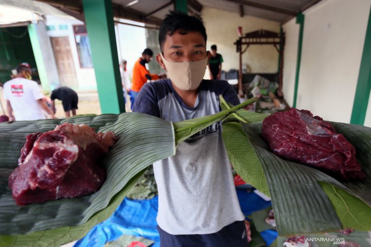 Warga menunjukkan potongan daging kurban yang siap dikemas emnggunakan daun pisang dan daun pohon jati di Blitar, Jawa Timur, Minggu (31/7/2020). Warga didaerah itu memanfaatkan dedaunan untuk membungkus daging kurban dengan tujuan untuk mendukung program